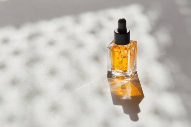 Çivi ve tırnak bakımı için şeffaf yağ cam şişelerde, beyaz arka planda doğal gölgeli pipet makinesi ile. Güzellik ve bakım konsepti. 