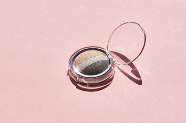 Pembe arka planda plastik bir kapta yeşil mineral göz falı paleti seti