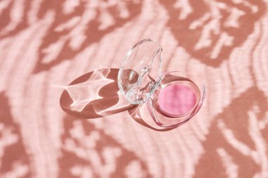 Pembe dudak parlatıcısı ya da pembe arka planda merhem olan açık bir kap. Dudak bakımı konsepti