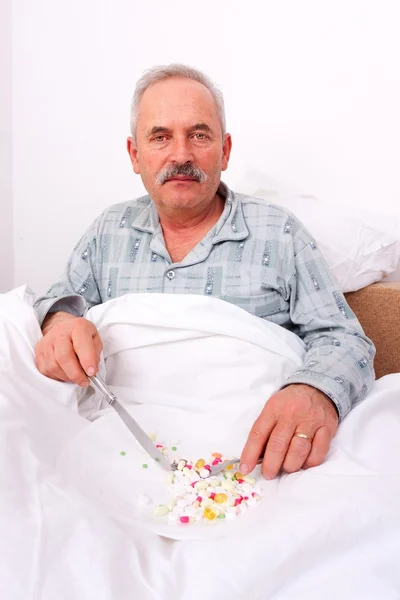 Starší muž jíst léky — Stock fotografie