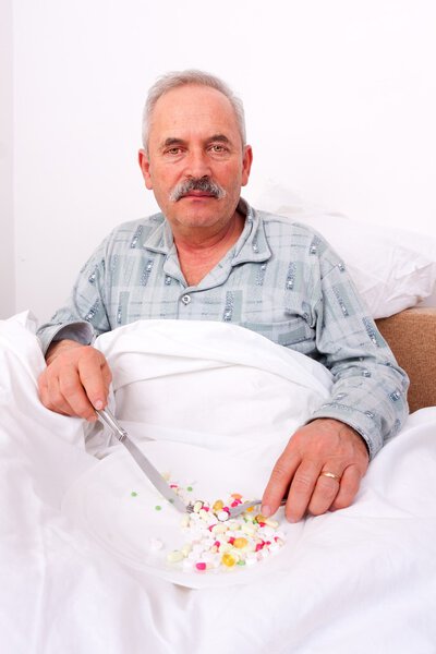 Elderly man eating meds