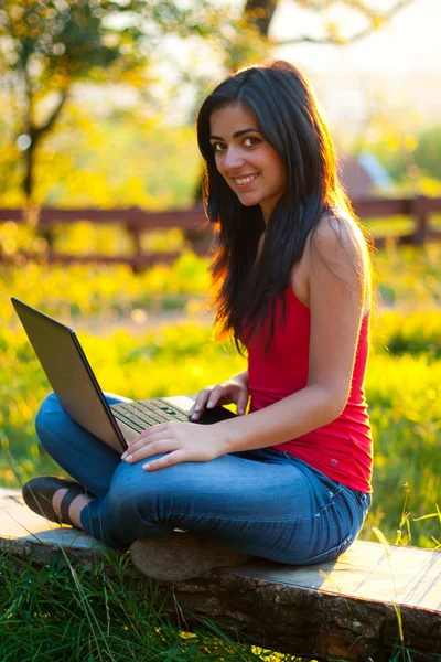 Menina bonita com seu laptop ao ar livre — Fotografia de Stock