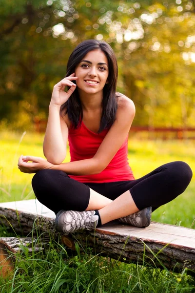 Young girl sitting outdoors on bench — Stock Photo, Image