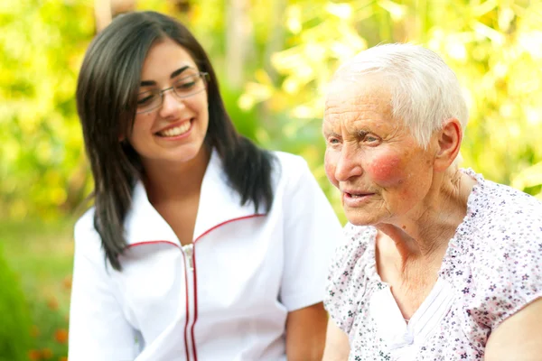 Caring doctor listening to old lady — Stock Photo, Image