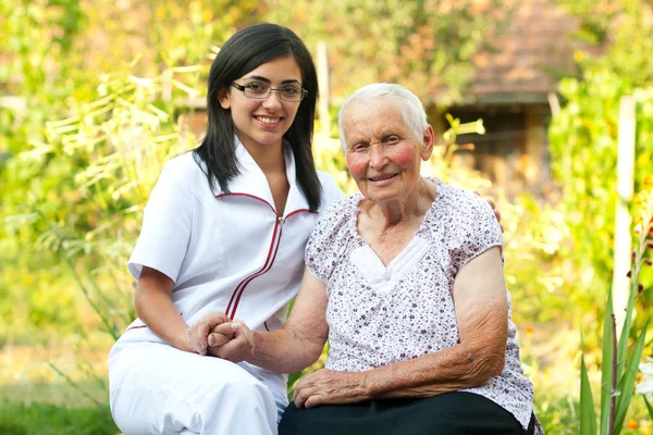 Yaşlı kadın ile bakan doktor — Stok fotoğraf