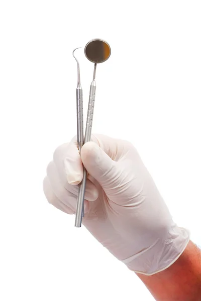Un dentista mani con guanti di gomma protettiva che tengono strumenti dentali: una sonda e uno specchio orale isolato su bianco . — Foto Stock