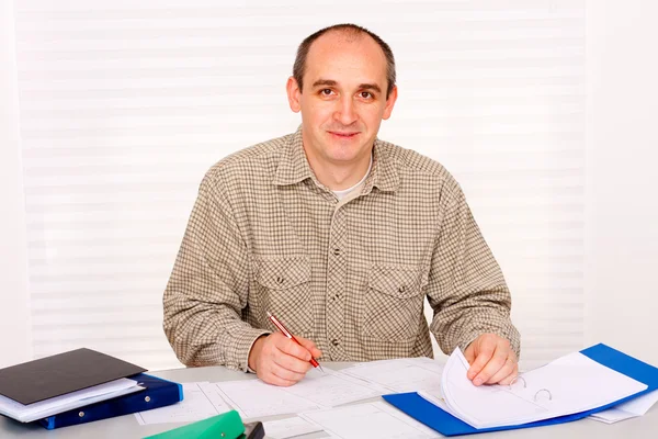 Un homme d'affaires adulte, étudiant travaillant à la maison, souriant, regardant gentiment à la caméra . — Photo