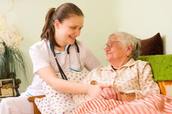 Helping a sick elderly woman Stock Picture