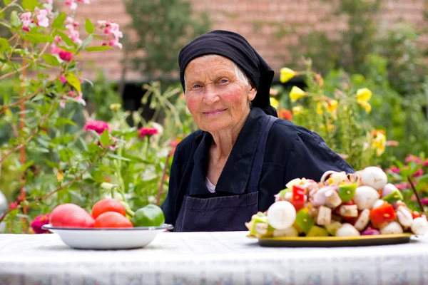 Ältere Frau am Tisch — Stockfoto