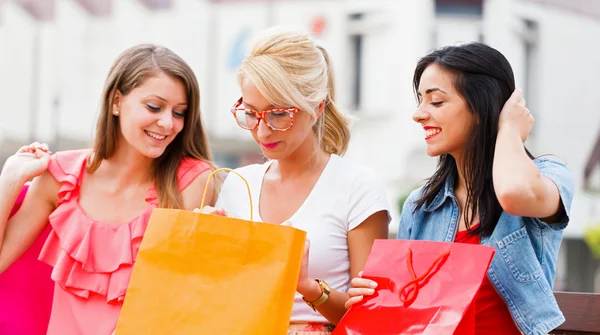 Meisjes zitten op de Bank met shopping tassen — Stockfoto