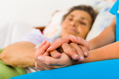 Caring nurse holding hands clipart