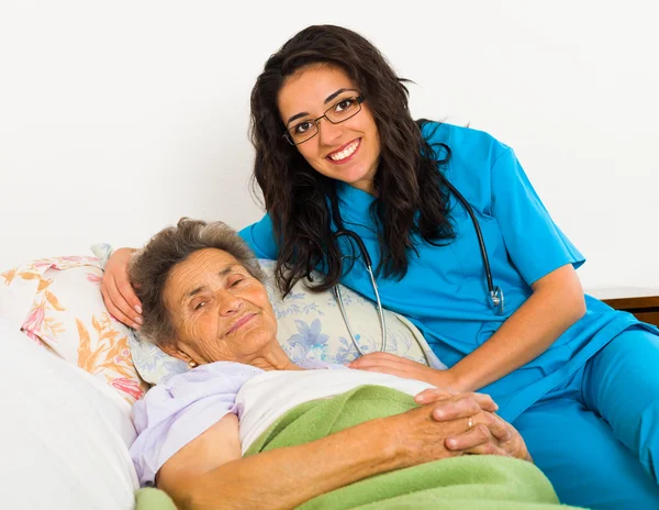 Sjuksköterskan vårdar äldre patient — Stockfoto