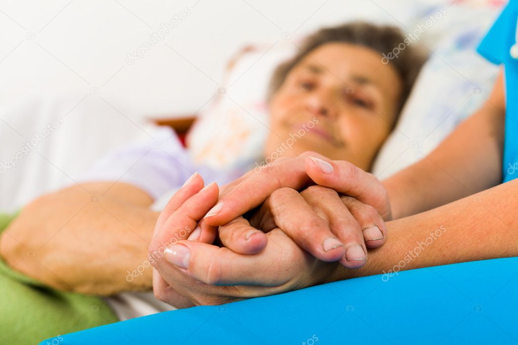 Caring nurse holding hands