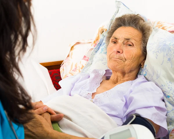 Sjuksköterskan vårdar äldre patient — Stockfoto