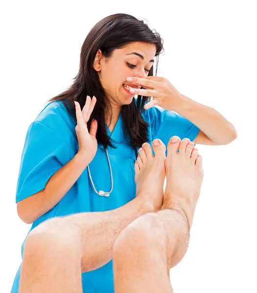 Doctor defending herself from stinky man feet — Stock Photo, Image