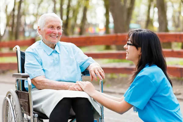 Krankenschwester plaudert mit Dame — Stockfoto