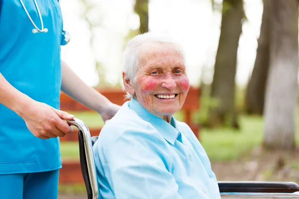 Femme âgée souriante en fauteuil roulant — Photo