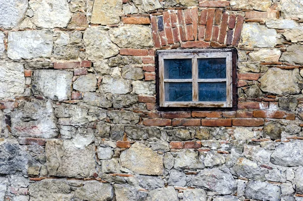 Taştan bir duvar üzerinde küçük bir pencere — Stok fotoğraf