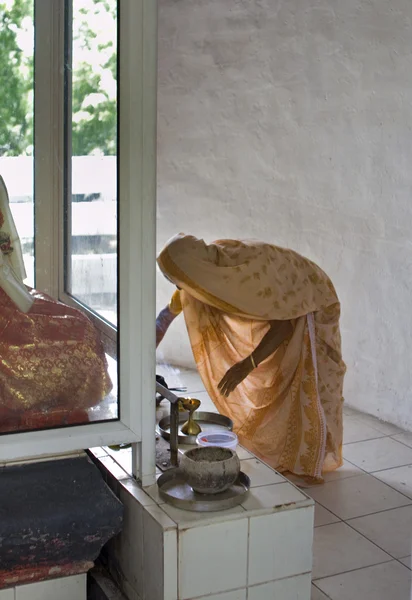 Unidentified Indian woman lights some incense in a Hindu temple