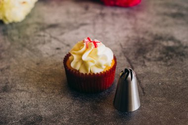 Lezzetli kekler. Krema için kapkekler ve şekerleme eklentileri. Kekler beton bir masada. 