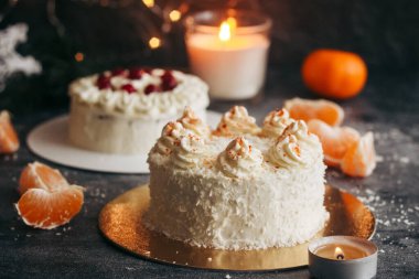 Noel pastaları. Kış dekorlu lezzetli kekler. Masada yaban mersinli kekler ve mandalinalar var. 