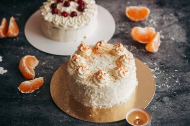 Noel pastaları. Kış dekorlu lezzetli kekler. Masada yaban mersinli kekler ve mandalinalar var. 