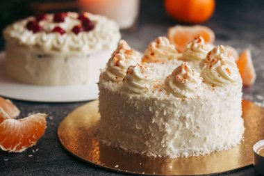 Noel pastaları. Kış dekorlu lezzetli kekler. Masada yaban mersinli kekler ve mandalinalar var. 