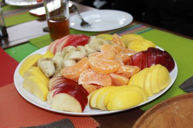 Dilimlenmiş meyve tabağı - muz, elma, portakal.