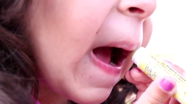 Una niña usando el lápiz labial de mamá — Vídeos de Stock