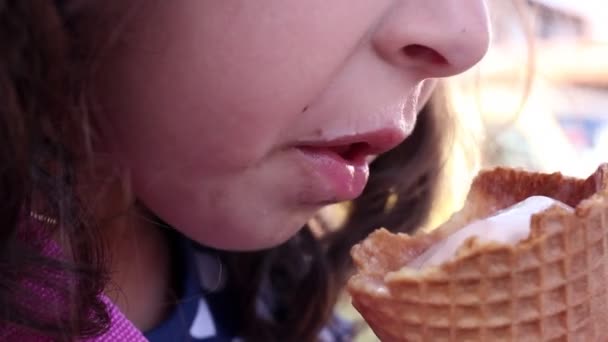 Een klein meisje eet een ijsje — Stockvideo