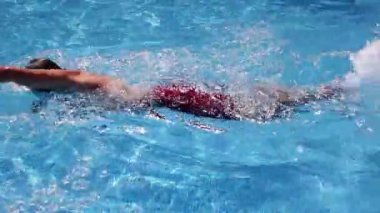 bir adamı serbest stil bir havuzda yüzüyor, kameranın su altında