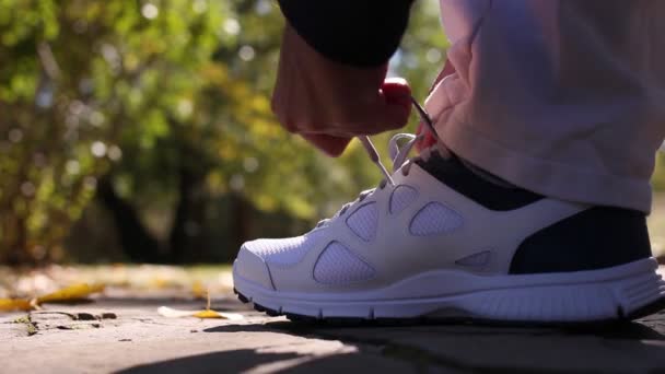 Um homem a correr, a correr no parque. Preparação da roupa . — Vídeo de Stock