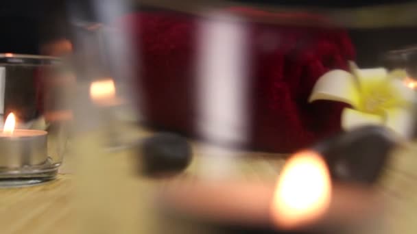 Piedras de terapia spa negro rodeado de velas — Vídeo de stock