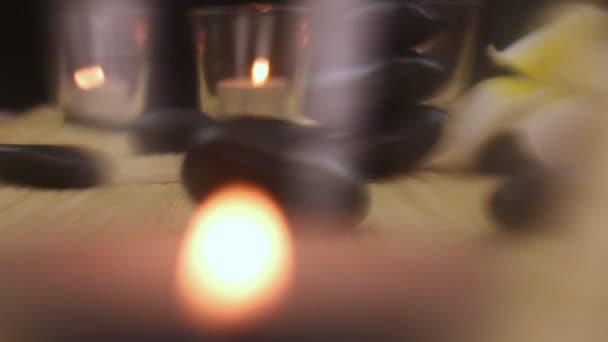 Černá lázeňské terapie kameny uprostřed svíčky — Stock video