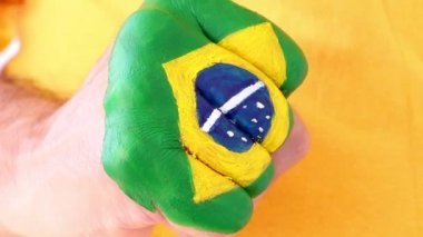 Brezilyalı futbol futbol fan kazanan bir jest, yumruğunu Brezilya bayrağı yapıyor