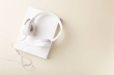 Top view of white headphones and notebooks on background with copy space. Flat lay. High quality photo