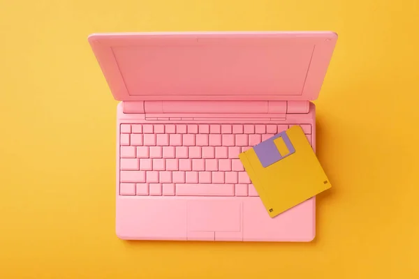 Colored pinColored pink laptop with bright floppy disk, modernity concept.k laptop with bright floppy disk, modernity concept. High quality photo