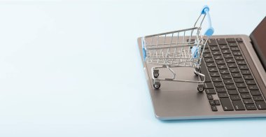 Online shopping concept. Shopping cart, small boxes, laptop on the desk. High quality photo