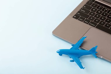 Ahşap bir masada dizüstü bilgisayarı olan bir uçak modeli. Oyuncak uçağı ve dizüstü bilgisayarı olan bir kompozisyon. Seyahat planlama konsepti. Küreselleşme, iş, işleme konsepti. Yüksek kalite fotoğraf