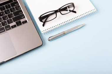 Malzeme, gözlük ve dizüstü bilgisayarlı ofis masası. Uzaktan ofis ve ev konseptinden çalışma. Kopyalama alanı olan. Yüksek kalite fotoğraf