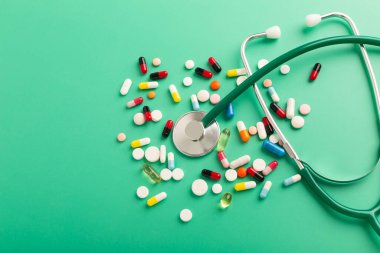 Kırık kalp hapları ve turkuaz arka planda fonendoskop. Yüksek kalite fotoğraf