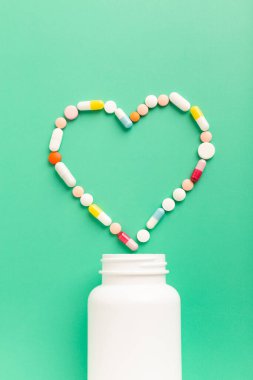 Kalp hastalıklarının tedavisi için çeşitli ilaç hapları ve kapsüller. Kalp şeklinde ve bir şişe hap. Uzayı metin için kopyala. Yüksek kalite fotoğraf