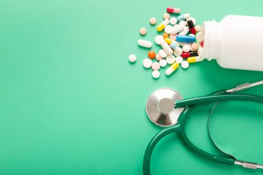 Farklı haplar ve antibiyotikler bir tıbbi kavanozdan masaya dökülür. Yüksek kalite fotoğraf