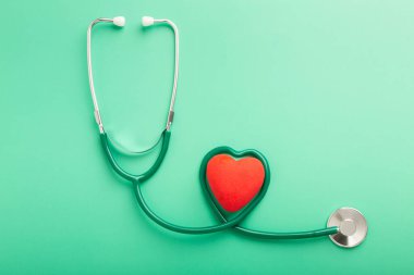 Healthcare and healthy lifestyle concept. Top above overhead close up view photo of black stethoscope and small red heart isolated over table background with copy blank empty space. High quality photo