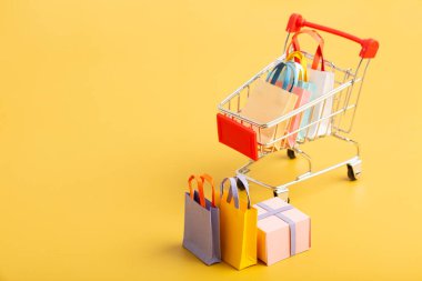 Trolley cart with colorful paper shopping bags isolated. Creative idea for shopping online, sale, supermarket, discount promotion and summer sale concept. High quality photo