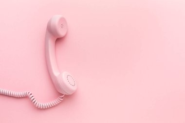 Pembe arka planda pembe telefon alıcısı. Yüksek kalite fotoğraf