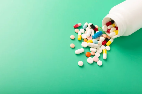 Different pills and antibiotics are spilled on the table from a medical jar. High quality photo