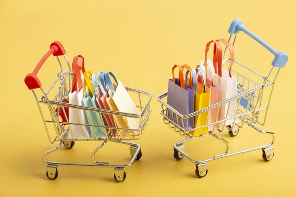 Trolley cart with colorful paper shopping bags isolated. Creative idea for shopping online, sale, supermarket, discount promotion and summer sale concept. High quality photo