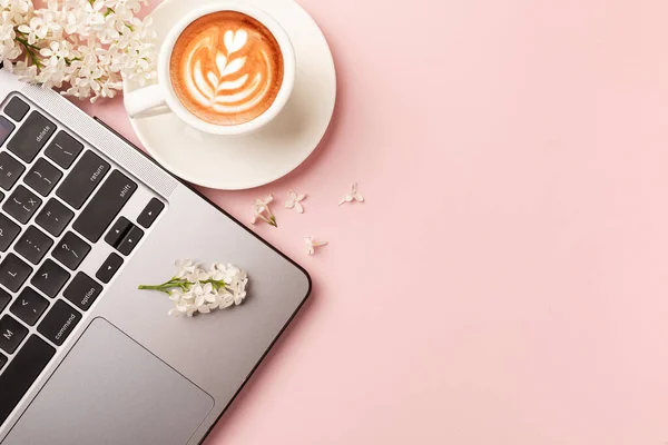 Working with Laptop computer,Hot coffee and cactus copy space on pink table background.Top view,Flat lay,style Minmal workspace,business Concept. High quality photo