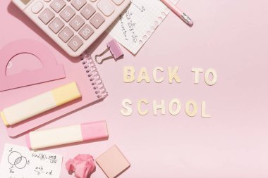 Lettering back to school on a pink background with school supplies. High quality photo